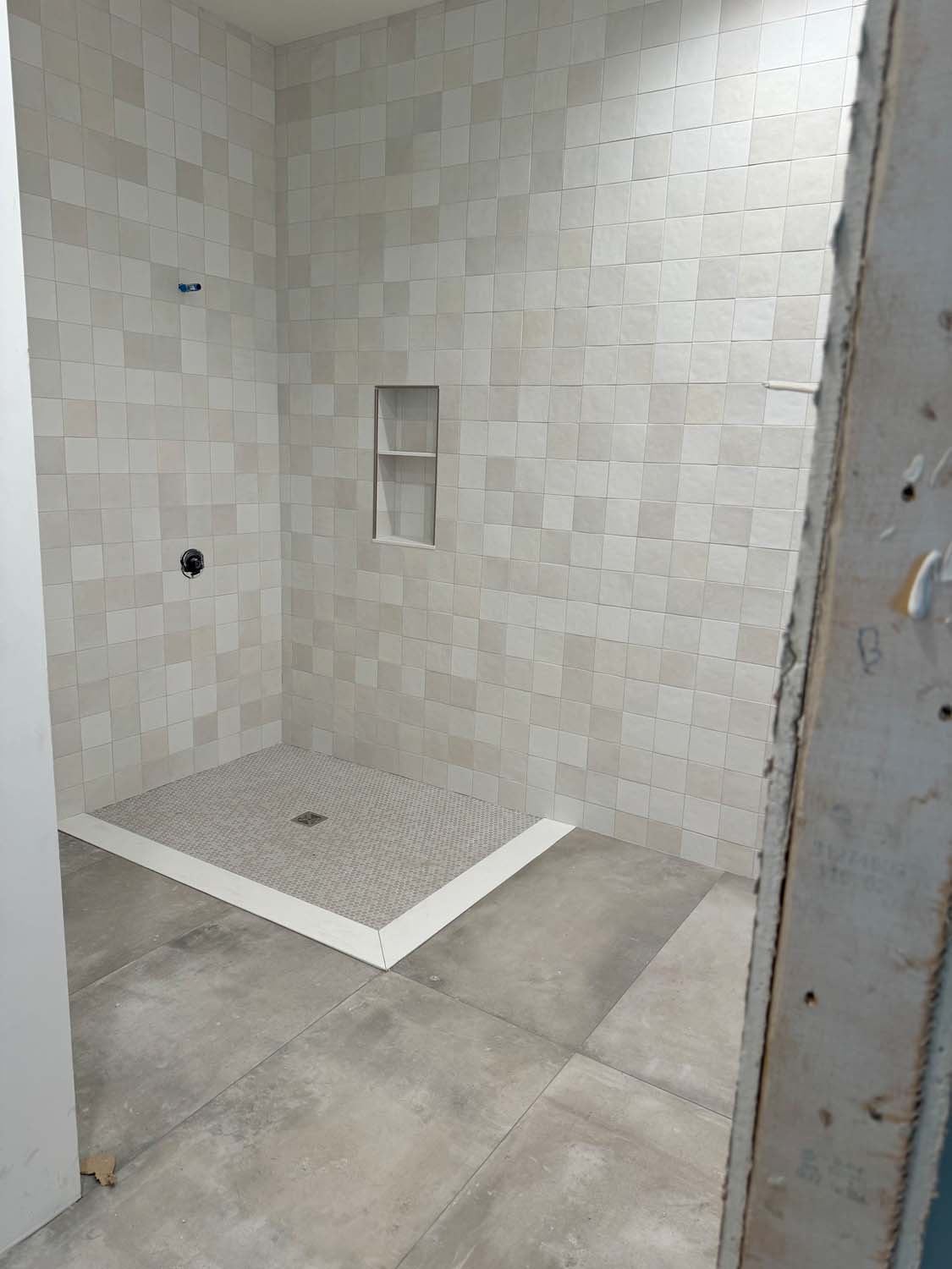 Square tile shower with a niche