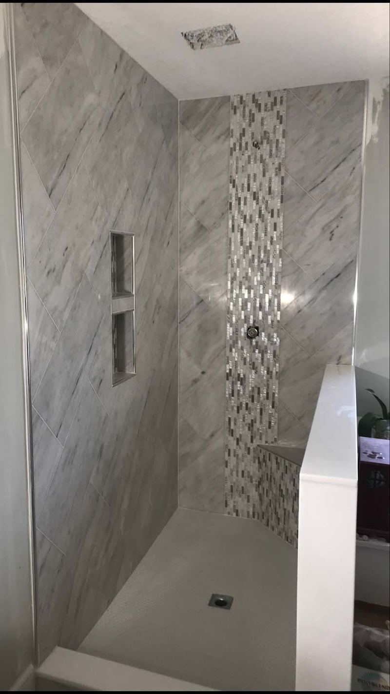 Shower with a vertical mosaic accent and two niches