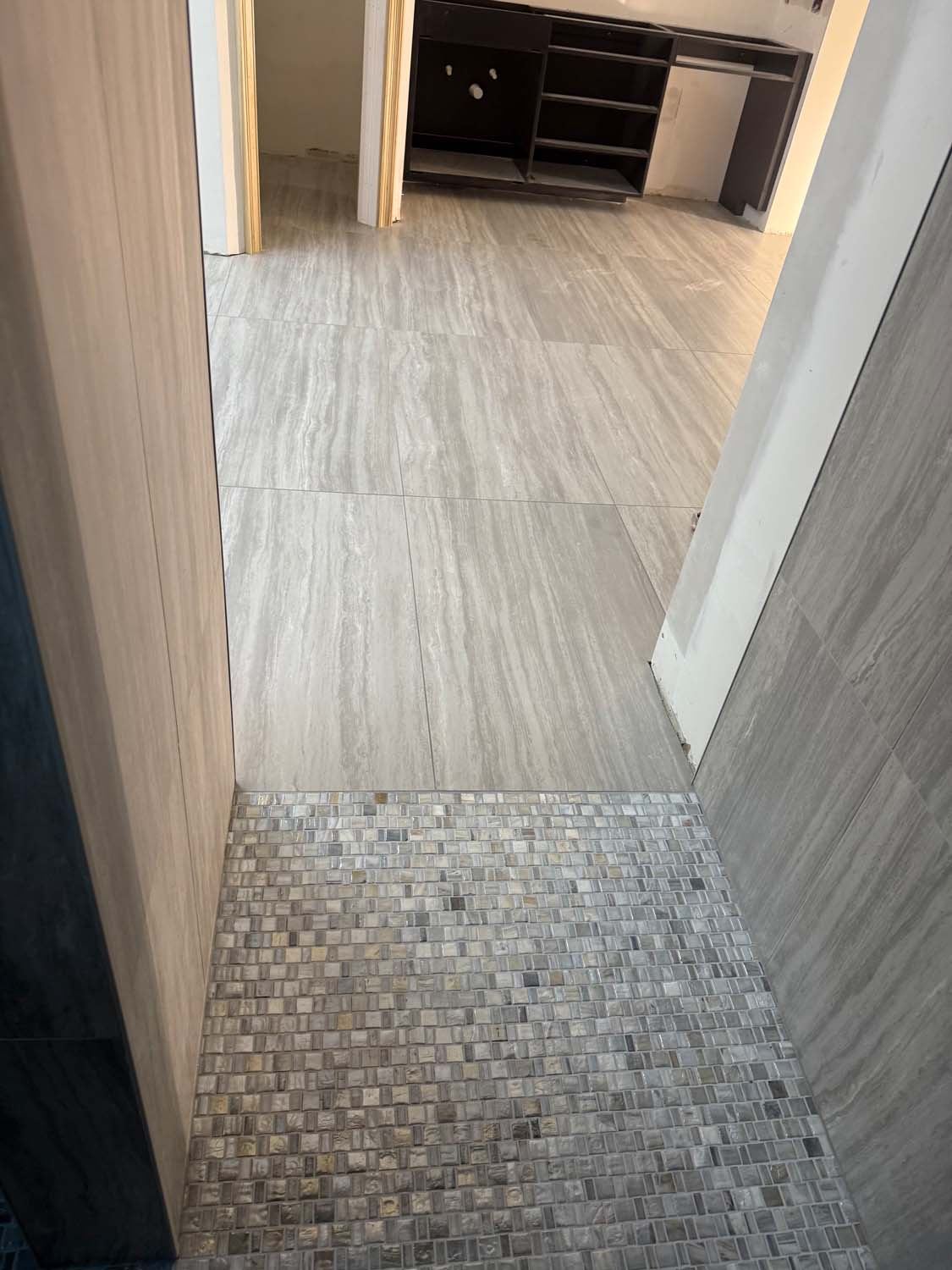 Plank tile floor leading to a mosaic shower floor