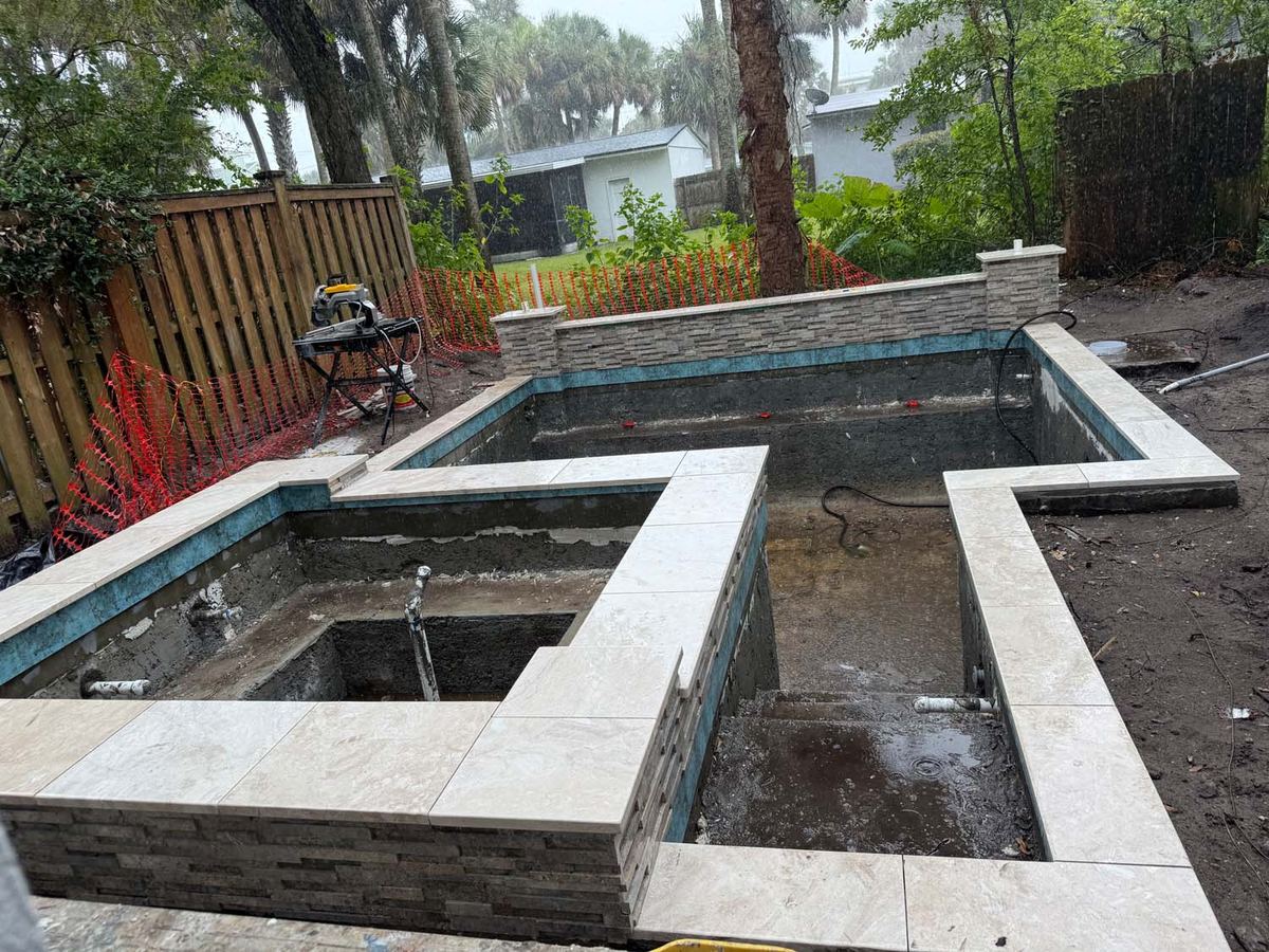 New pool shell with stone coping and a stacked stone wall