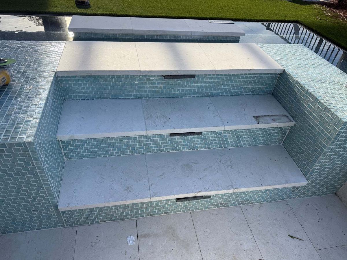 Pool steps in blue glass mosaic with stone treads