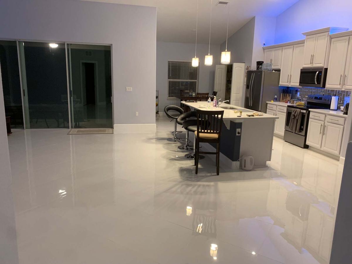 Polished large-format porcelain floor through an open kitchen